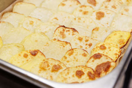 Baked potato slices on cooking pad, close-upの写真素材