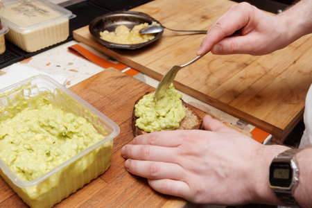 Chef is cooking bruschettas with avocado mash - guacamole sauceの写真素材