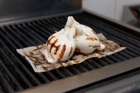 Frying stuffed squids on grill, mediterranean dish
