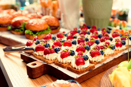 Desserts and burgers on table, hotel dinner board, toned