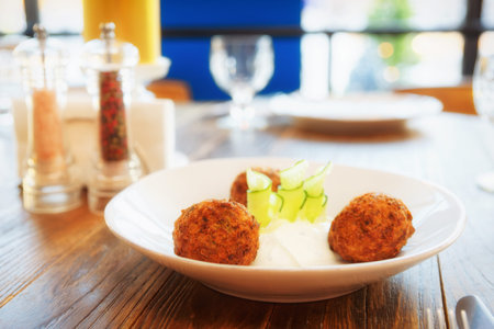 Vegetable croquettes with sour cream on restaurant table, Greek dish, toned
