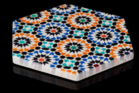 Cup coaster with Andalusian ornament isolated on black background