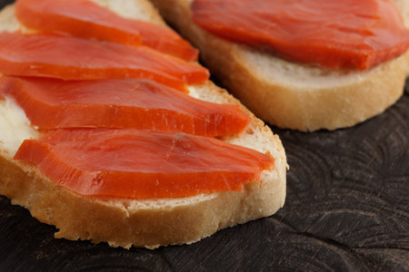 Open-face sandwiches with smoked trout on wooden board, close-upの写真素材