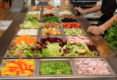 Salad bar with various fresh vegetables and other foodsの写真素材