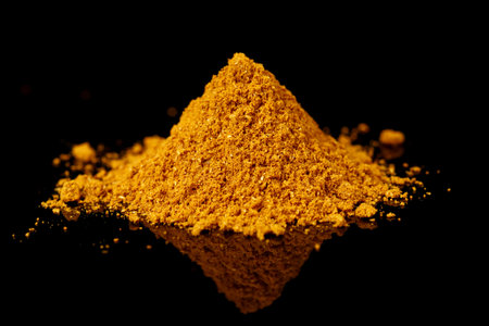 Pile of curry powder shot on black reflective surface, Indian food stapleの写真素材