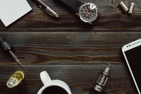 Vaping set, watch, coffee and smartphone with copy space on the wooden background. Hipster or bussinesman style.の写真素材