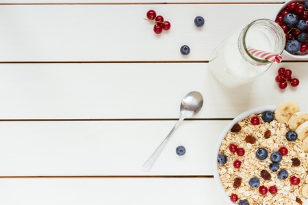 Healthy breakfast with berries and milk on the white wooden table with copy space, top view.の写真素材
