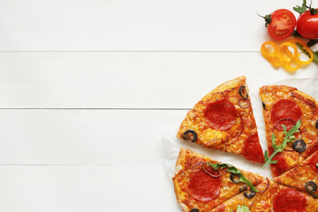 Fresh delisious sliced pizza on the wooden table with copy space, top view.の写真素材