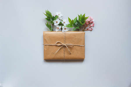 Cute gift box wrapped with craft paper and flowers top view. Gift for any holiday.の写真素材