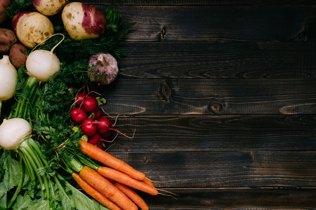 Organic vegetables background. Fresh harvested vegetables on the dark wooden background, top view, with copy space.の写真素材