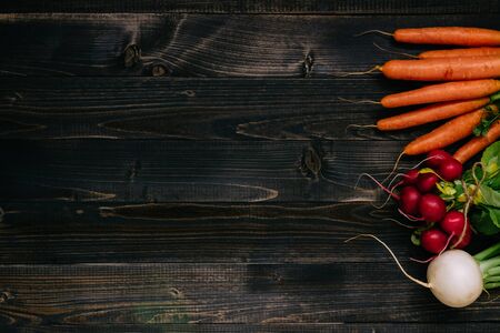 Organic vegetables background. Fresh harvested vegetables on the dark wooden background, top view, with copy space.の写真素材