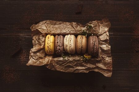 Delicious macaroons in gift box on the wooden table, top view.の写真素材