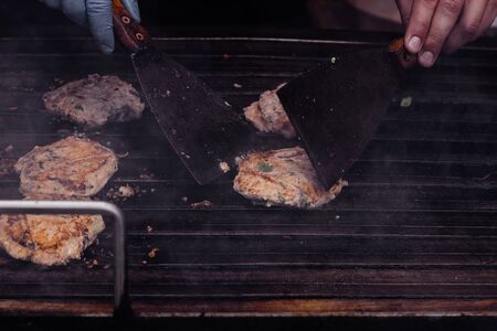 Cooking delicious fish burgers on the grill outdoor.の写真素材