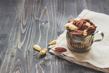 Nuts mix. Cashews, almonds and pecans on the wooden table, with copy space.