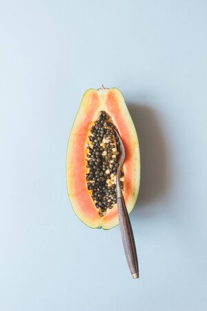 Fresh ripe papaya with spoon on the blue background, top view.の写真素材