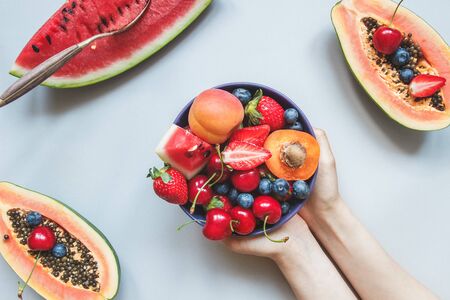 Summer fruits. Fresh juicy berries, watermelon and papaya on the blue background, top view.の写真素材