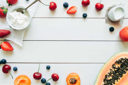 Summer fruits. Fresh juicy berries and papaya on the white wooden table, top view.の写真素材