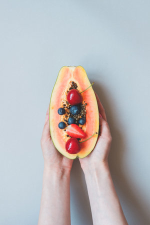 Summer fruits. Fresh juicy berries and papaya on the blue background, top view. Summer backgroundの写真素材