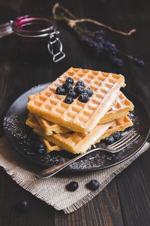 Homemade belgian waffles with blueberries on the dark wooden table.の写真素材