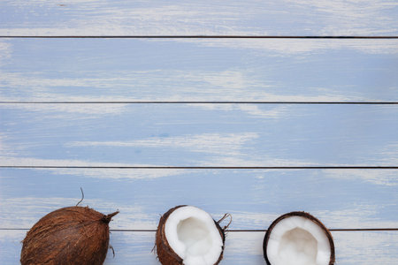Ripe coconut on the wooden blue table, top view, with copy space.