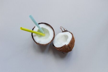 Ripe coconut with straw on the gray background, top view, with copy space.の写真素材
