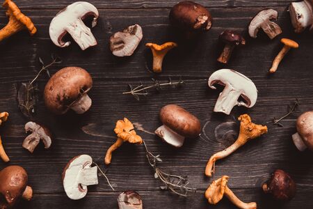 Fresh mixed forest mushrooms on the wooden background, top view.の写真素材