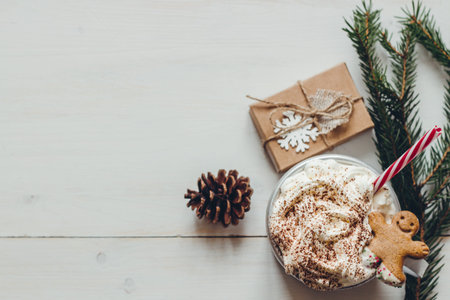 Winter hot drink with gingerbread men cookie and christmas decoration on the wooden white table....