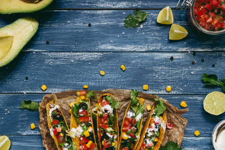 Mexican tacos with salsa and avocado on the wooden blue background, top view. Copy spaceの写真素材