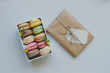 Cute gift box with delicious colorful macaroons on the light blue background, top viewの写真素材