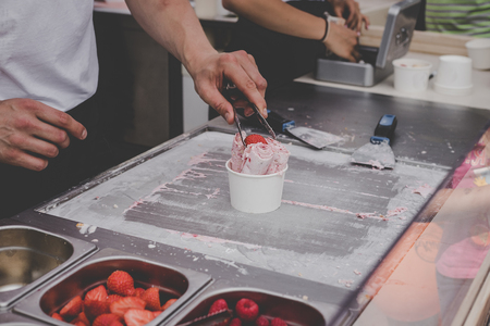 Delicious strawberry ice cream rolls at street food market, ready to eat.の写真素材