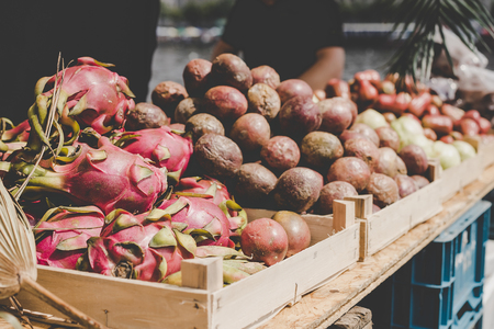 Exotic tropical fruits. Dragon fruits and passion fruits at street food market.の写真素材