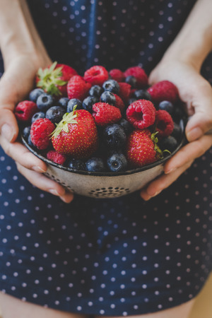 Organic fresh harvested berries. Hands holding fresh juicy berries, closeupの写真素材