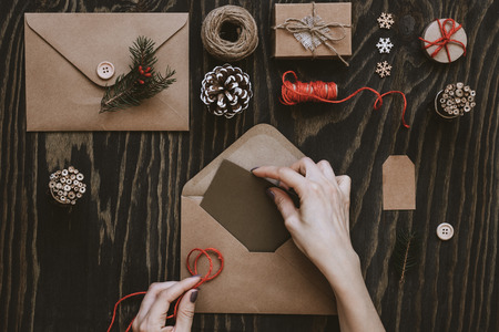 Christmas handmade cards and gifts. Hand making christmas card on wooden table, top view.の写真素材