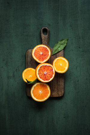 Citrus fruit background. Ripe juicy oranges on cutting board. Green background top viewの写真素材