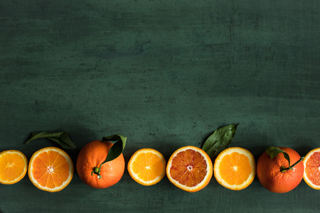 Orange fruits background. Juicy oranges on green background top view with copy spaceの写真素材