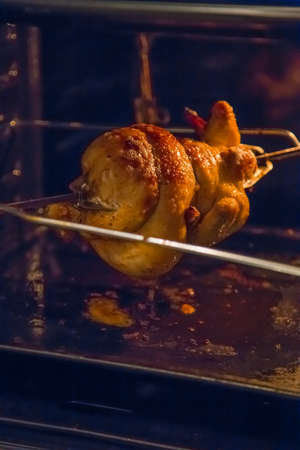 grilled chicken in the oven on a spitの写真素材