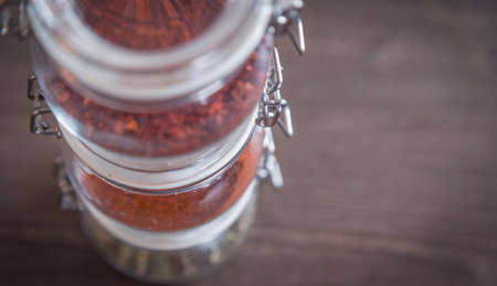 Garlic and spices in glass jars on wooden backgroundの写真素材