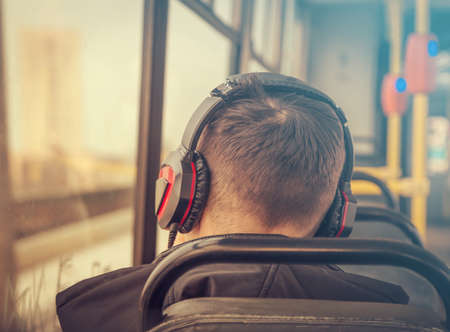 young man in headphones in a tram close upの写真素材