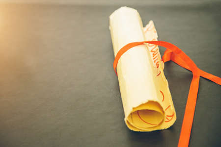 old paper scroll on wooden background close-upの写真素材