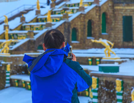 back view man making a picture on the phone in winterの写真素材