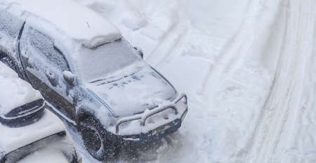 top view parked cars snowed during a snowfallの写真素材