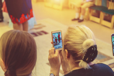 woman taking a picture of children on the phone in kindergarten close up