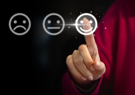 Female hand pressing smiley face icon on virtual screen. Customer service conceptの写真素材