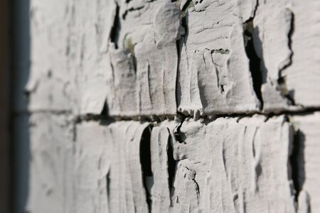The old cracked grey paint on a wall of the houseの写真素材