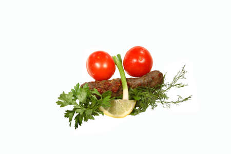 Kebab, tomatoes, onion, parsley and lemon on a white backgroundの写真素材