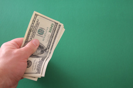 Hand with US paper currency on a green backgroundの写真素材