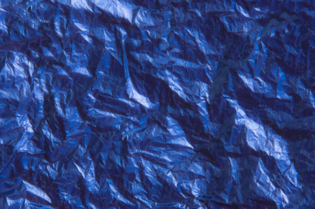 Abstract texture of crumpled blue bright shiny paper