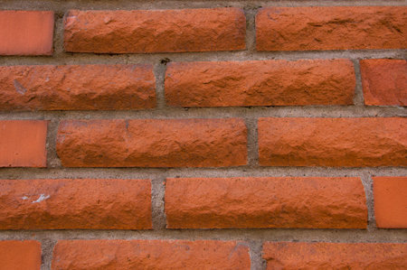 Texture of a red vintage brick wall of a building close up
