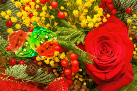 Christmas festive bouquet of red roses, berries, fir branches, cones, old glass toys close upの写真素材