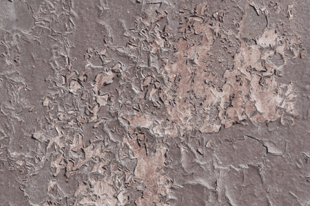 Texture of an old stone painted brown wall with cracks close up